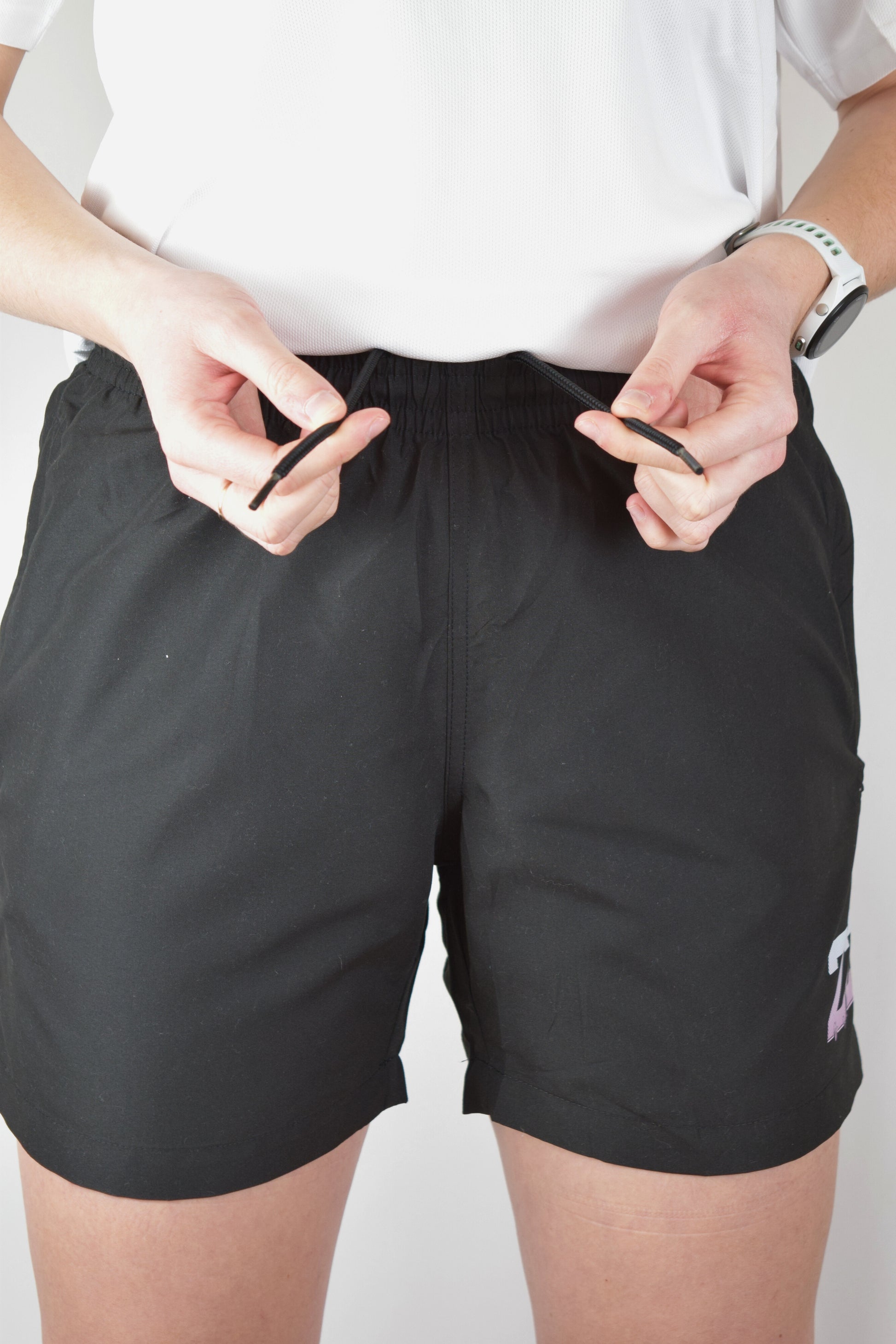 Lady wearing quick dry athletic shorts demonstrating the drawstring in the waistband