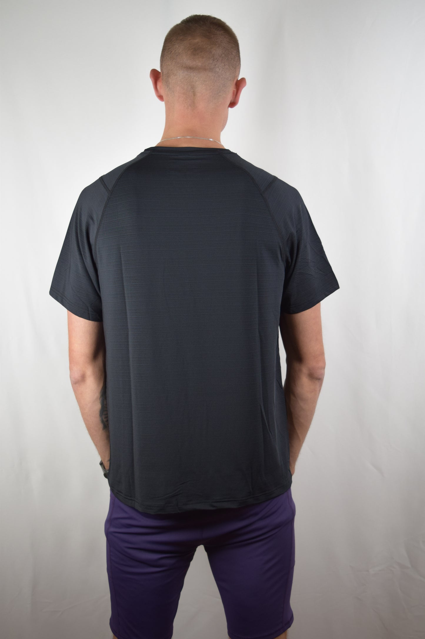 Core performance running top in black, facing away from the camera