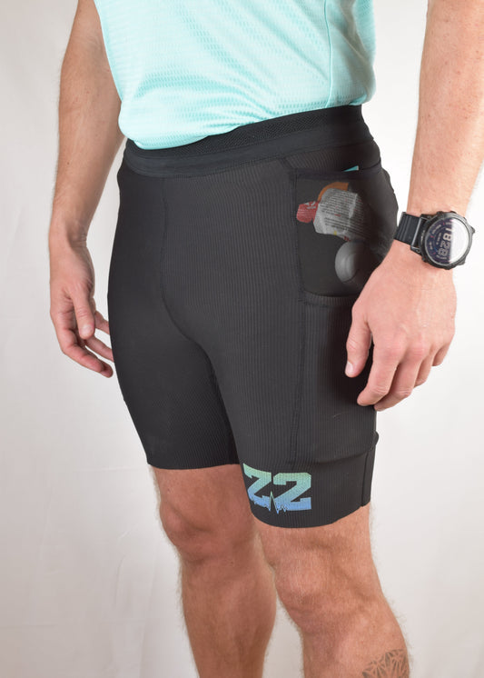 The enduro tights in black from a 45 degree angle showing the pockets stuffed full of items.