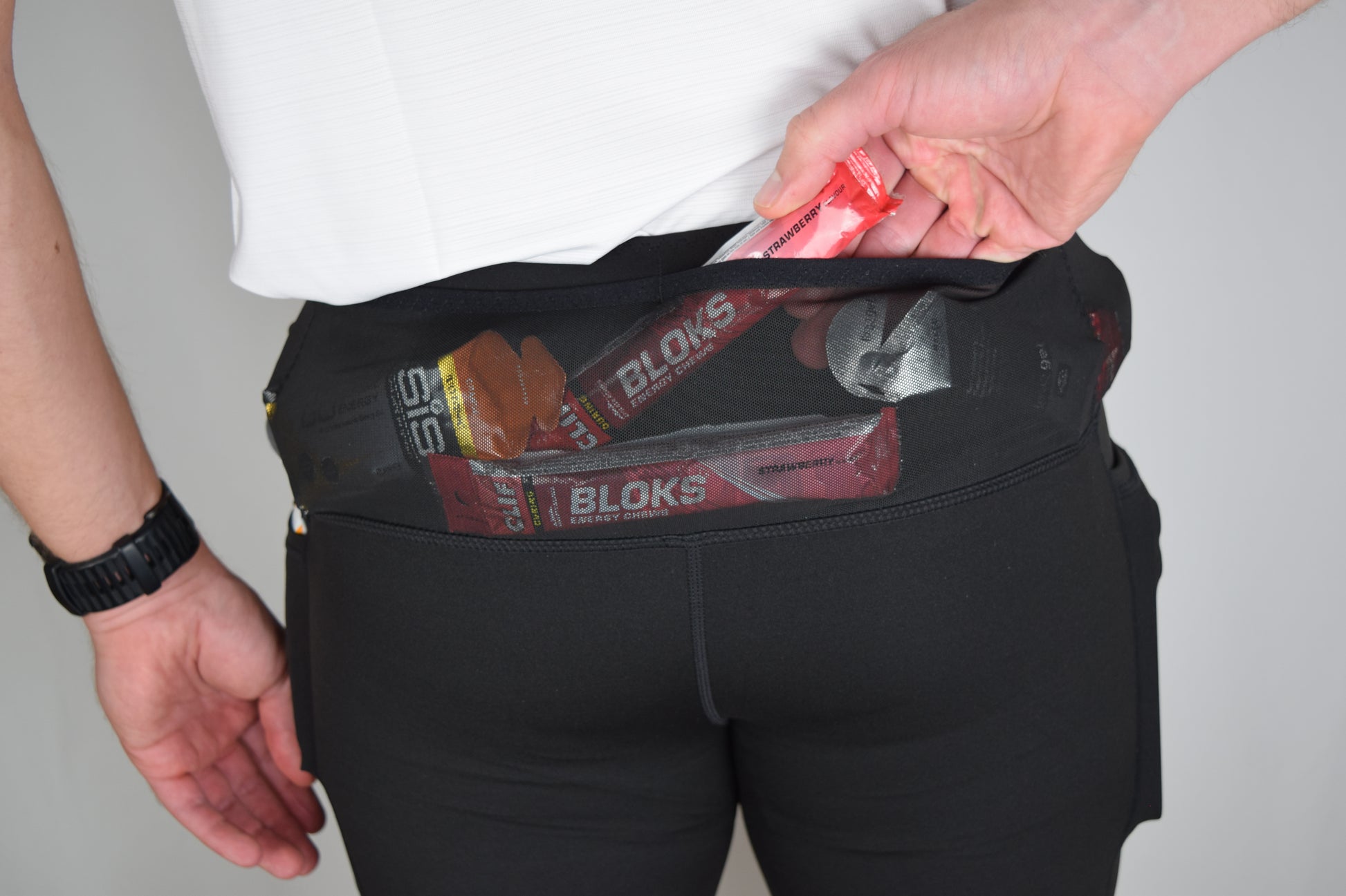 Orbit half tights in Black demonstrating their built in running belt and generous pockets, notably the rear pockets with multiple gels inside.