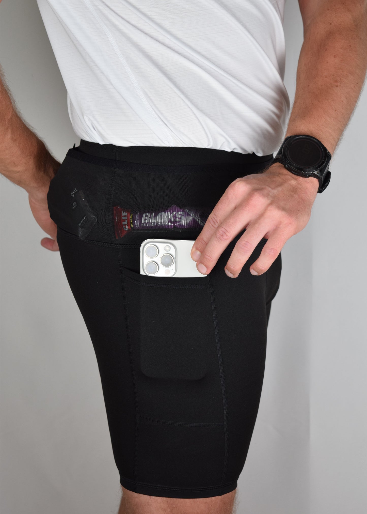 Orbit half tights in Black demonstrating their built in running belt and generous pockets, including a secure phone pocket