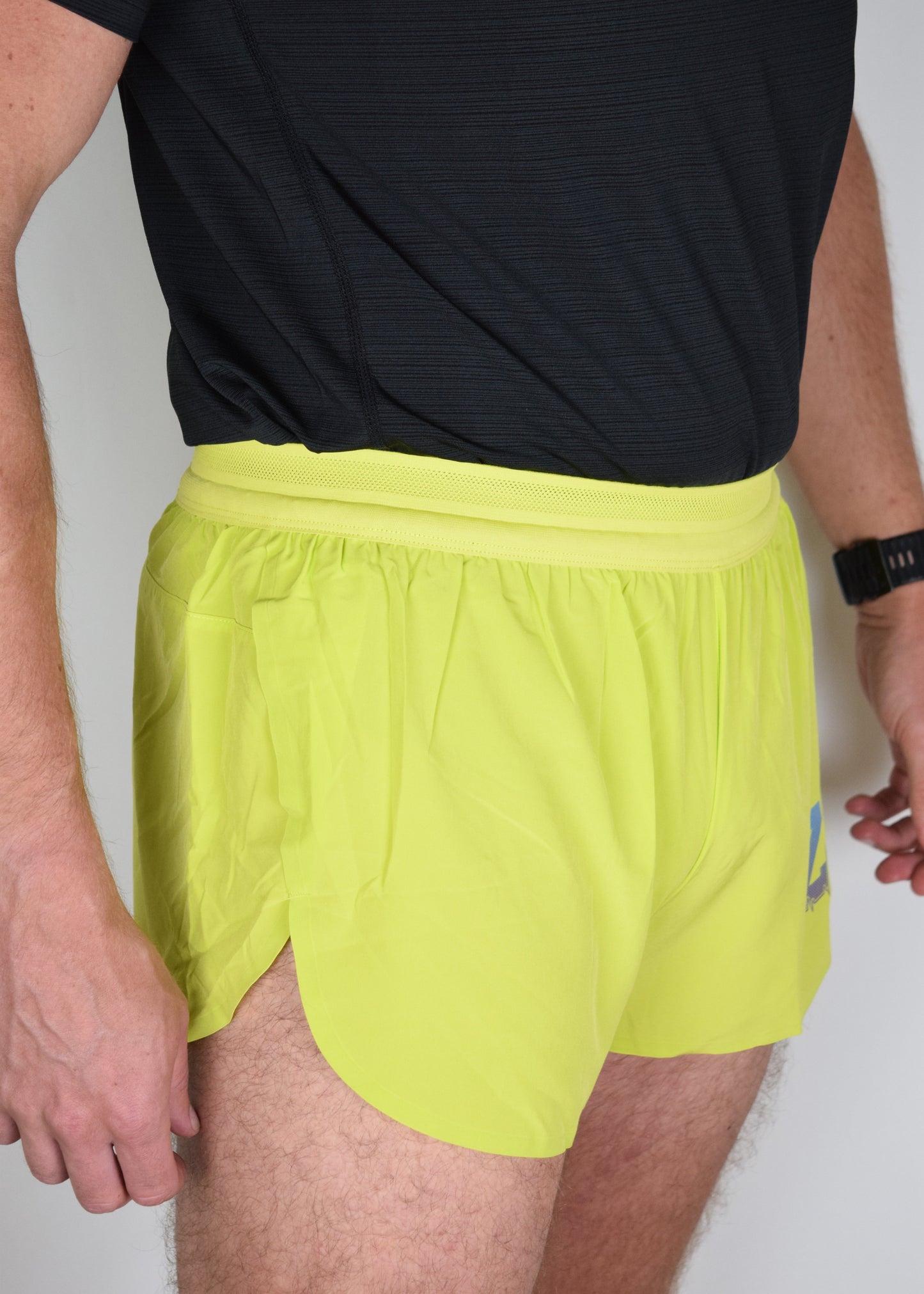 Stride 4 inch running performance shorts in yellow, facing 45 degrees focussing on the right leg
