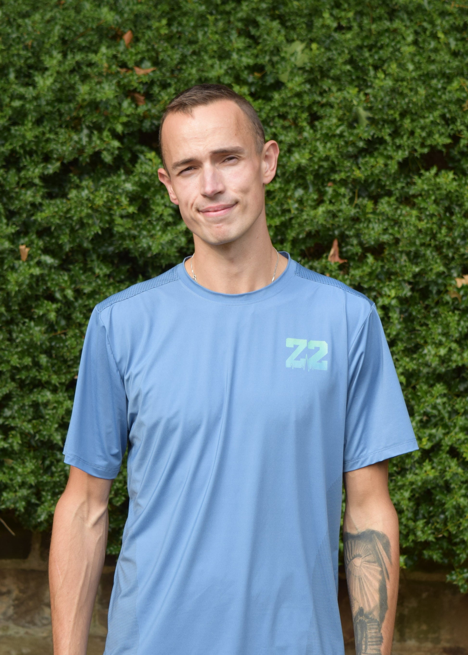 The Split Tee Technical Running T-Shirt in blue in an outdoor setting