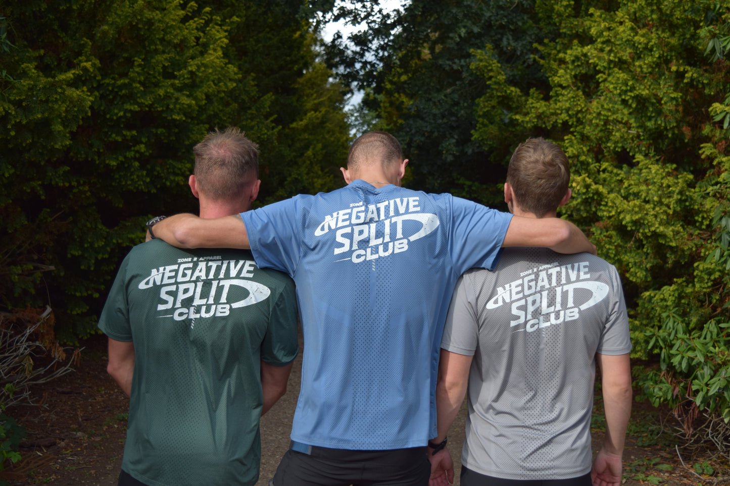 Three individuals wearing negative split technical running t-shirts in different colours, facing away from the camera.