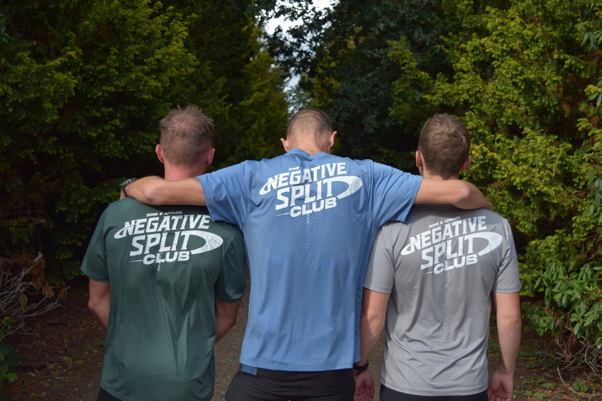 Three individuals wearing negative split technical running t-shirts in different colours, facing away from the camera.