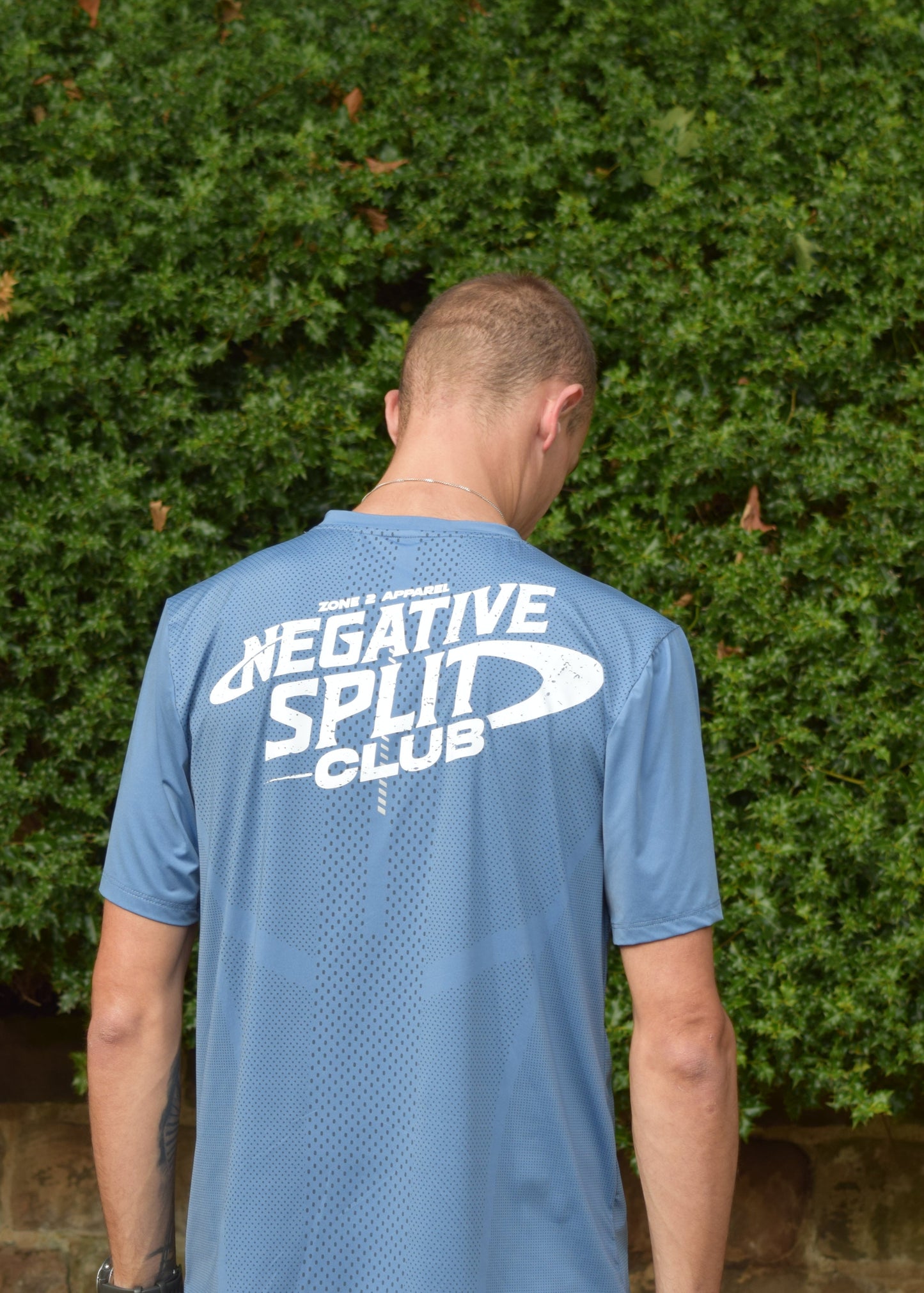 The Split Tee Technical Running T-Shirt in blue with the model facing away from the camera